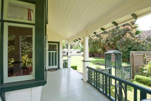 a porch of a house with a green door at Gumnut House. in Whanganui