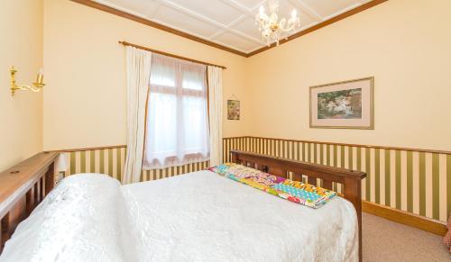 a bedroom with a bed and a window at Gumnut House. in Whanganui