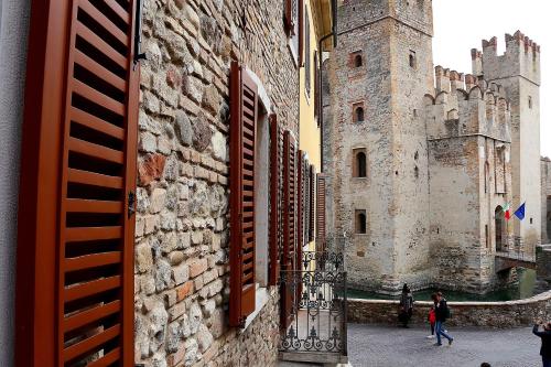 um edifício com um castelo com pessoas a andar à volta dele em Aurora Sirmione Appartamenti em Sirmione