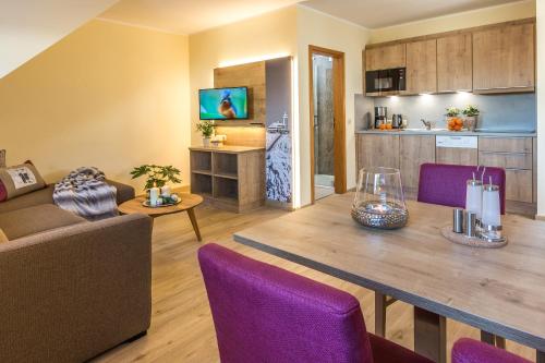 a living room with a table and purple chairs at Simon´s Ferienwohnungen in Kurort Oberwiesenthal