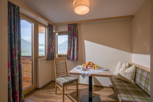 a room with a table and chairs and a window at Appartements Rofan in Maurach