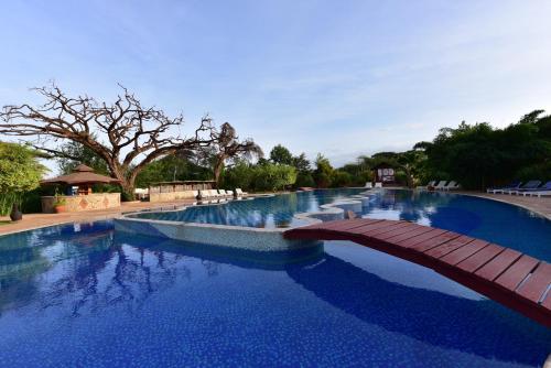 une grande piscine avec un pont en bois dans l'établissement Kilima Safari Camp, à Amboseli