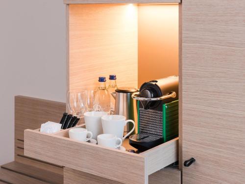 d'un placard avec des tasses et des boissons. dans l'établissement Hotel Savoy, à Berne