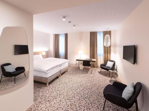 une chambre d'hôtel avec un lit et deux chaises dans l'établissement Hotel Savoy, à Berne