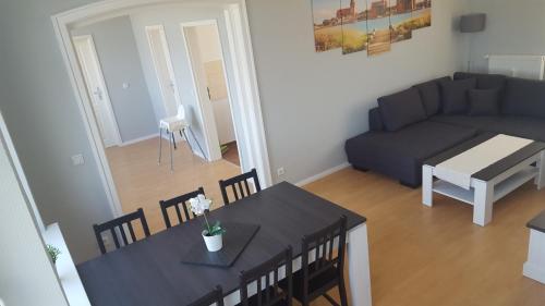 sala de estar con mesa y sofá en Pension Fischerjung, en Rostock