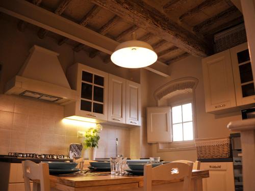 a kitchen with a table with chairs and a light at Appartamento il Battistero in Pistoia