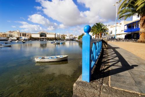 een boot in het water naast een blauw hek bij Top Charco San Gines Stunning View Lanzarote By PVL in Arrecife