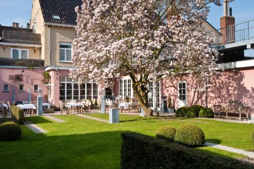 een magnolia boom in een park voor een gebouw bij Hotel Recour in Poperinge