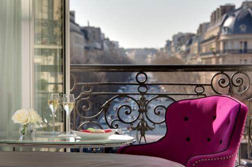 un tavolo con una sedia rosa e un tavolo con un piatto di cibo di La Villa Haussmann a Parigi