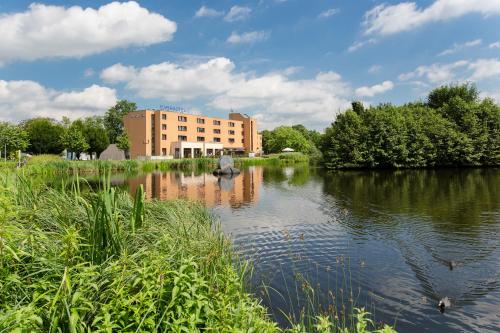 een gebouw naast een rivier met een gebouw bij Montana Parkhotel Marl in Marl