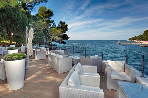 eine Terrasse mit weißen Möbeln und Blick auf das Wasser in der Unterkunft Apartments Galijot Plava Laguna in Poreč