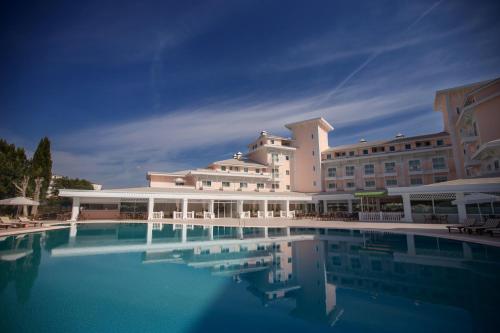 - un grand bâtiment avec une piscine en face dans l'établissement Innvista Hotels Belek, à Belek