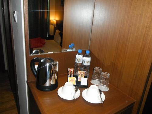 a table with a tea kettle and bottles of water at Keoja Hotel in Kuala Belait