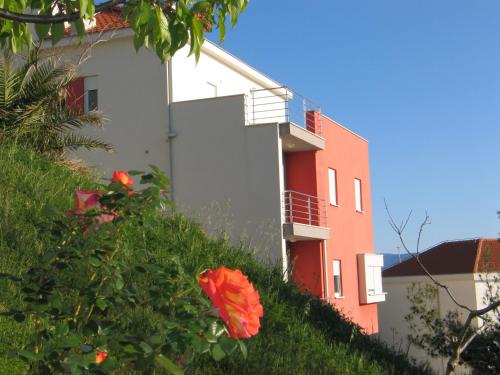 a white and red building with a red flower at Luxury Apartments Villa Lenka in Podstrana