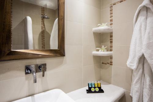 a bathroom with a sink and a mirror at Daedalus Hotel in Fira