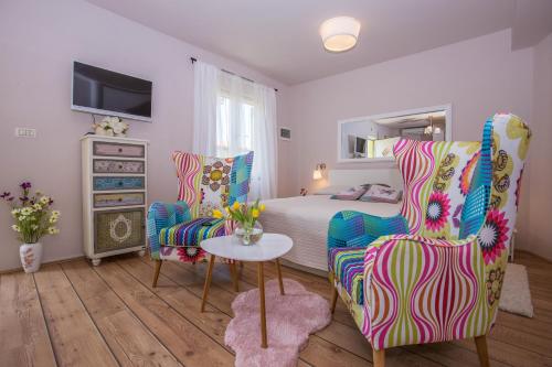 una camera con un letto e due sedie e un tavolo di Apartments Javor a Rovigno (Rovinj)