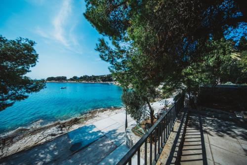 a view of a beach with a fence and water at Pine Beach Villa in Hvar