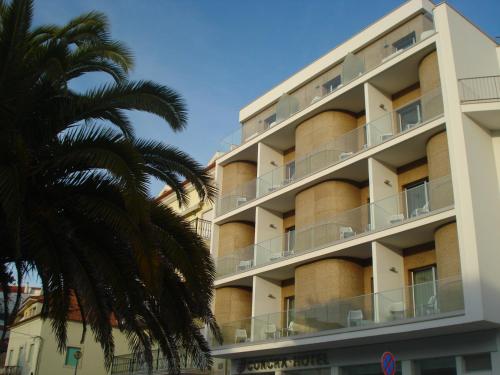 um edifício com uma palmeira em frente em Hotel Concha em São Martinho do Porto