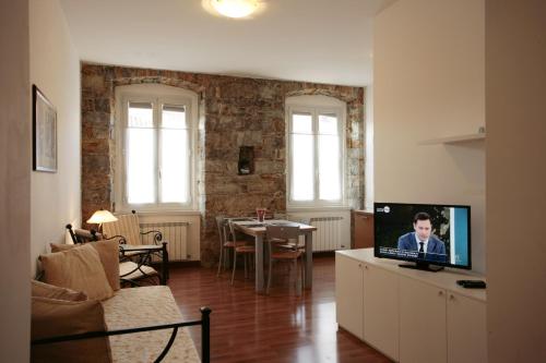 ein Wohnzimmer mit einem Sofa und einem TV auf einem Schrank in der Unterkunft Residence Theresia- Tailor Made Stay in Triest