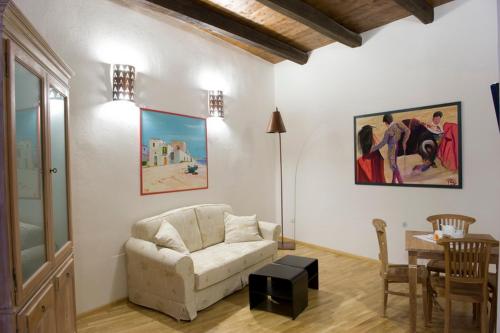 uma sala de estar com um sofá e uma mesa em Castelletto Suites em Cagliari