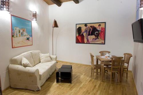 uma sala de estar com um sofá e uma mesa em Castelletto Suites em Cagliari