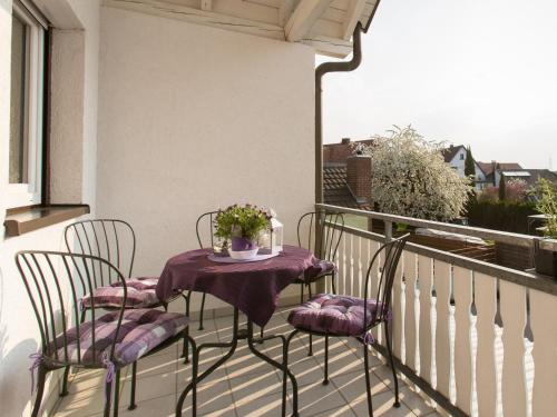 a balcony with two chairs and a table with flowers at Ruster Drachennest in Rust