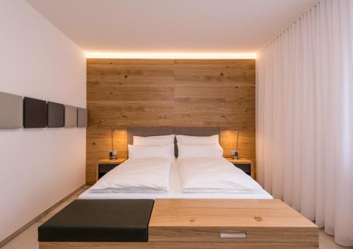 Schlafzimmer mit einem großen Bett mit einem Kopfteil aus Holz in der Unterkunft 24/7 Zimmer Asten in Asten