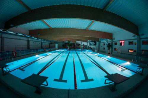 ein Pool mit blauen Lichtern in einem Gebäude in der Unterkunft Apartamenty, Pokoje, Noclegi pracownicze " Skarpa" Wilkasy in Wilkasy