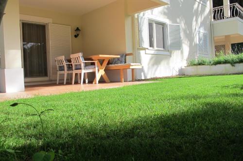 une terrasse avec une table et des chaises sur une pelouse dans l'établissement Quinta do Lago Golf, à Quinta do Lago