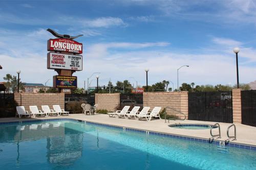 een hotelzwembad met een bord en stoelen bij Longhorn Boulder Highway in Las Vegas