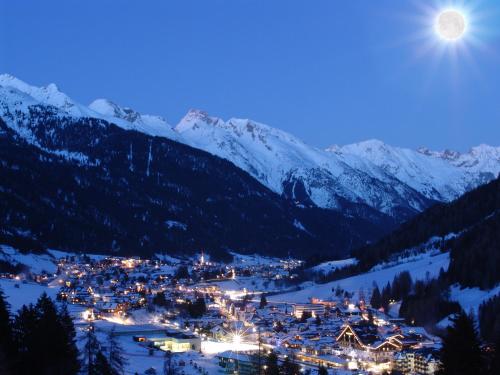 una estación de esquí en las montañas por la noche con la luna en Arpuria l hidden luxury mountain home - ADULTS FRIENDLY, en Sankt Anton am Arlberg