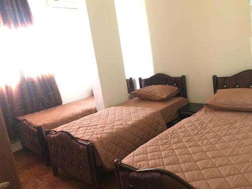 sypialnia z 2 łóżkami i oknem w obiekcie Sami Hostel w mieście Jerycho