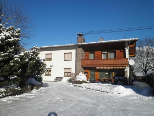 une maison avec de la neige devant elle dans l'établissement Haus Stratton, à Innsbruck