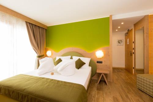 een slaapkamer met een groot bed met een groene muur bij Green Rose in Livigno