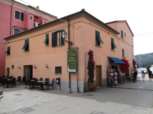 un edificio con mesas y sillas en una calle en Casa Porto Azzurro, en Porto Azzurro