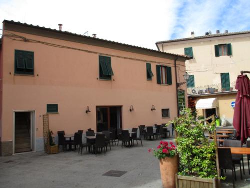 un patio con mesas y sillas frente a un edificio en Casa Porto Azzurro, en Porto Azzurro