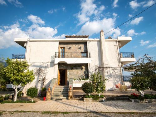 una gran casa blanca con escaleras delante en Paradeisos, en Kardhamili