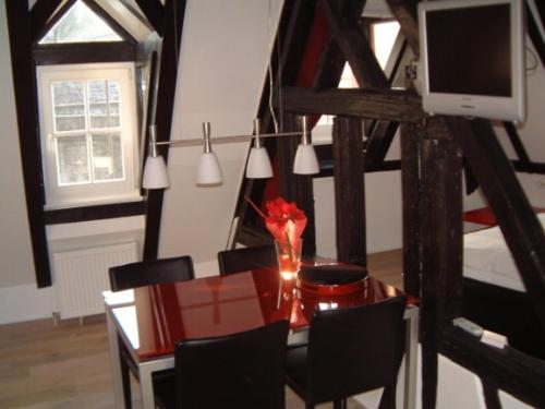 a dining room with a table with chairs and a television at Appartement Kirschgarten Mainz Rochusstraße in Mainz