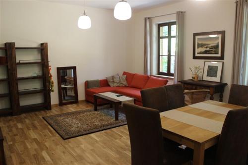 a living room with a red couch and a table at Willa Widok - Apartament Naleczow in Nałęczów