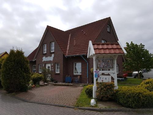 una casa con un cartel delante de ella en Ferienhaus Poseidon, en Neuharlingersiel