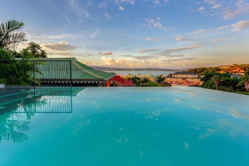 une grande piscine avec vue sur la ville dans l'établissement La Suite Villa, à Les Trois-Îlets