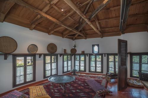 uma grande sala de estar com uma mesa e janelas em Urania Traditional Stone House em Pinakátai