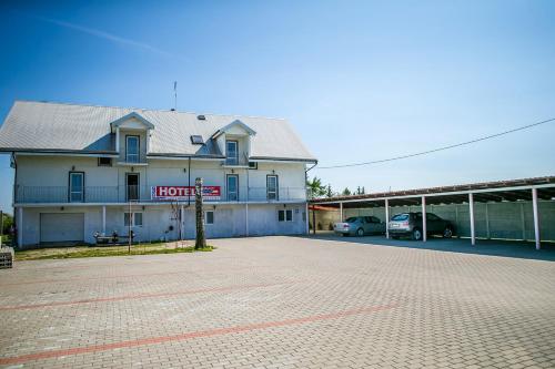 ein Hotelgebäude mit auf einem Parkplatz geparkt in der Unterkunft Usługi Hotelarskie Małgosia i Andrzej Danowski in Grajewo