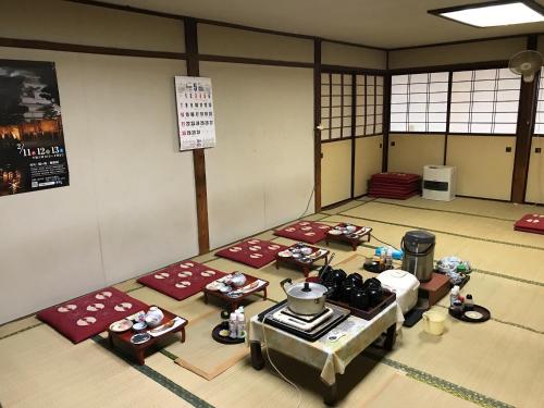 een kamer met rode matten op de vloer van een kamer bij Niko Ryokan in Aizuwakamatsu