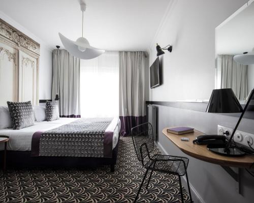 um quarto de hotel com uma cama e uma secretária em Hotel Malte - Astotel em Paris