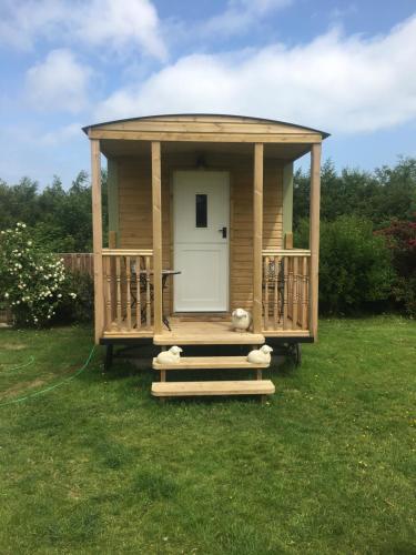 um gazebo com uma porta num campo de relva em Orme View Lodges em Bangor