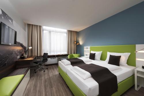 Pokój hotelowy z dużym łóżkiem i biurkiem w obiekcie ibis Styles Offenburg City w mieście Offenburg