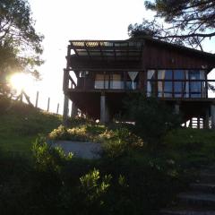 Cabaña en la playa. ventanales y terraza al mar