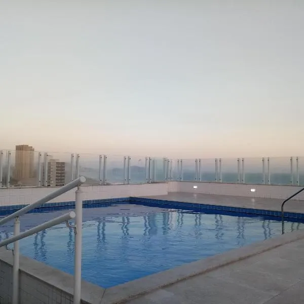 Prédio com piscina na cobertura frente ao mar, apartamento para até 6 adultos e 3 crianças até 8 anos, churrasqueira na sacada, Wi-Fi grátis, NÃO oferecemos roupas de cama e banho, 1 vaga de garagem, na Praia Grande-Vila Mirim, khách sạn ở Praia Grande