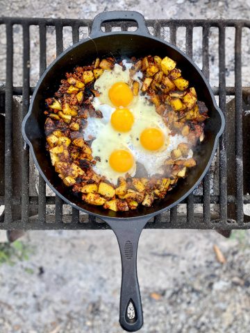 Campfire hash with eggs, potatoes and chorizo in skillet.